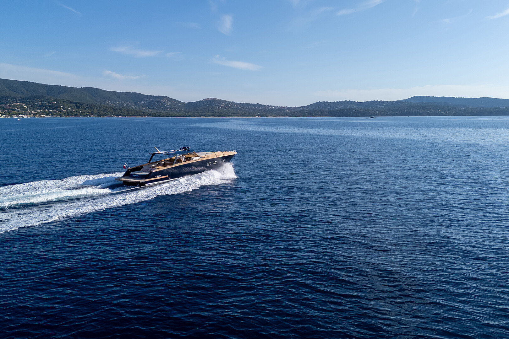 “Chaloupe” on the open sea with the coastline in the background